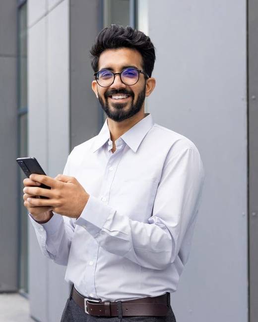A consultant holding his phone outside an office